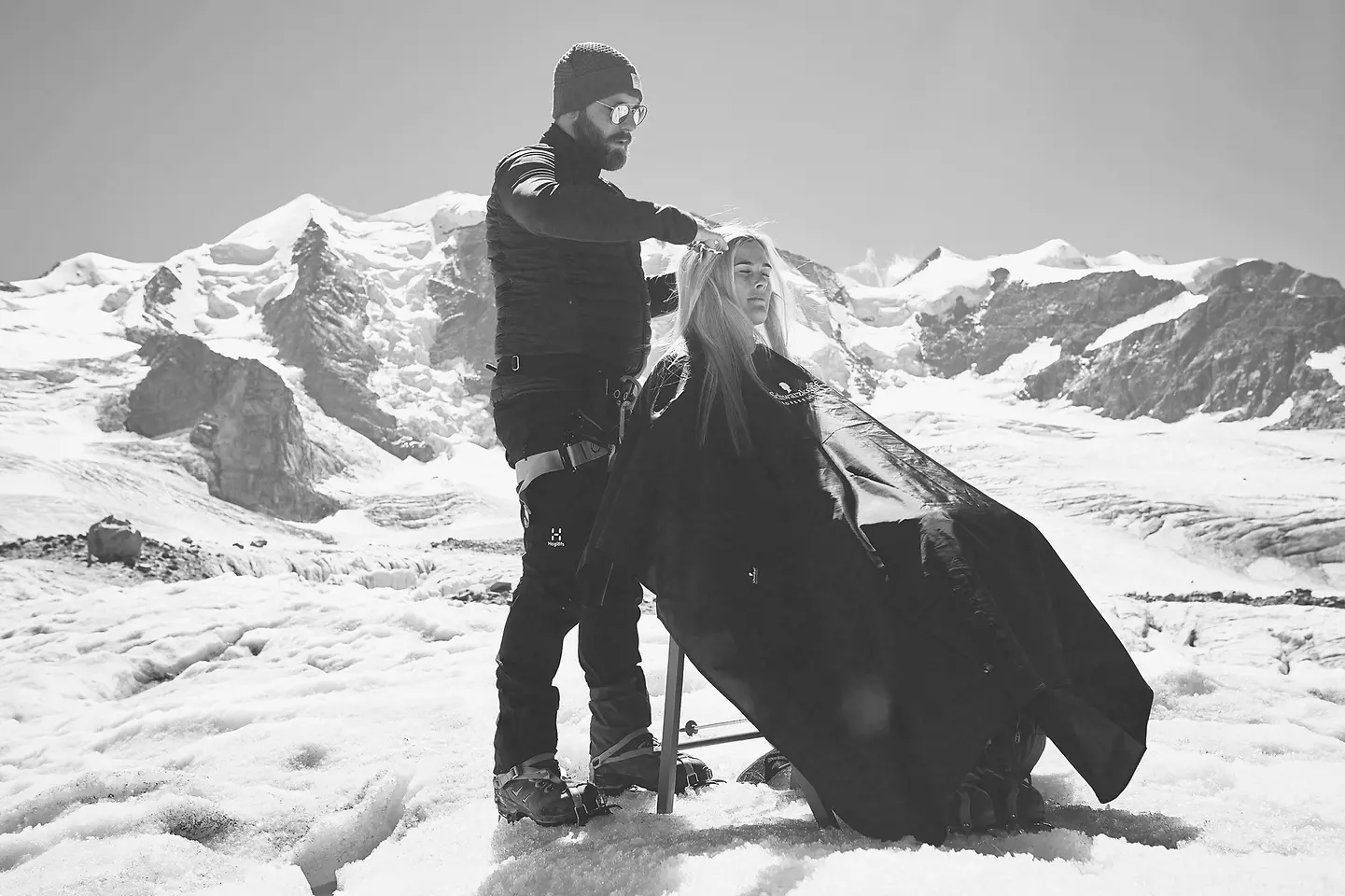 Friseur schneidet auf einem Berg die Haare.