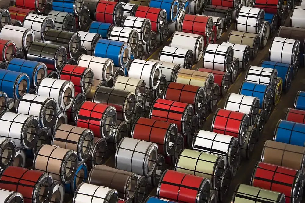 Gestapelte Metallteile oder -spulen, angeordnet in einem Industrie-Lager.