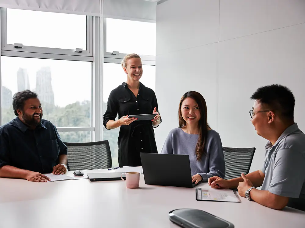Eine vielfältige Gruppe von Fach- und Führungskräften arbeitet in einem modernen Meetingraum gemeinsam an einem Tisch mit Laptops und Dokumenten. Die Szene steht für Henkels Engagement für Gender Balance und Vielfalt in Führungspositionen sowie für ein inklusives Arbeitsumfeld, in dem unterschiedliche Perspektiven zur Entscheidungsfindung beitragen.