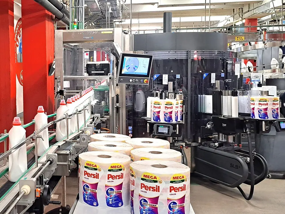 Automatisierte Anlage zum Befüllen und Verschließen von Persil-Waschmittelbehältern.