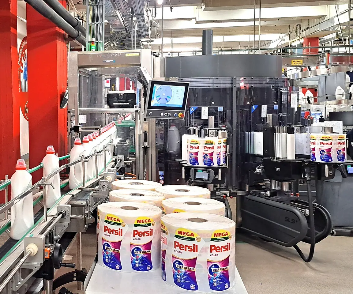 Automatisierte Anlage zum Befüllen und Verschließen von Persil-Waschmittelbehältern.