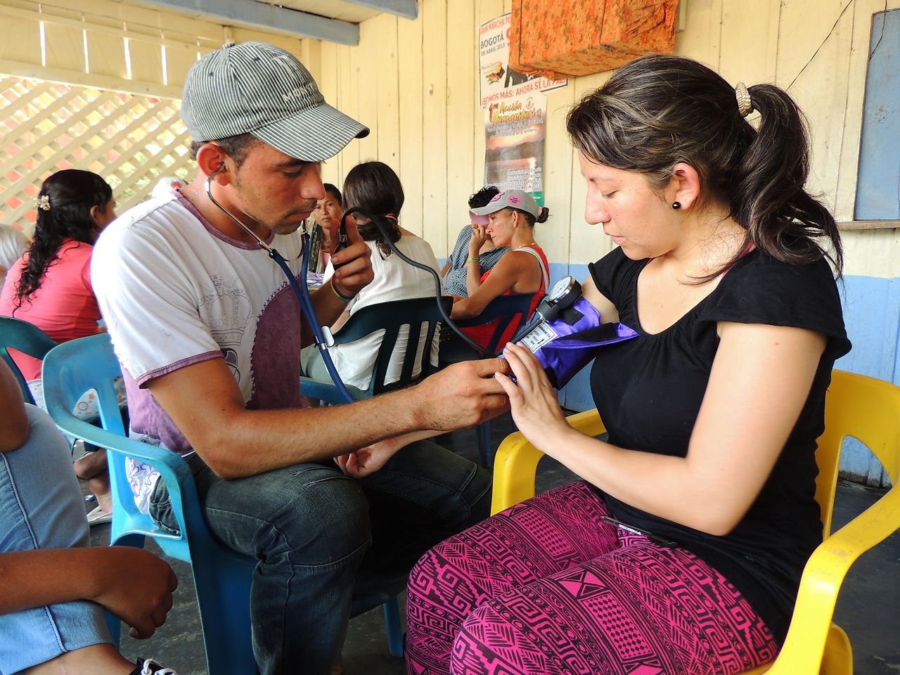 With the help of a medical student (right), a member of the Valle del Río Cimitarra community learns how to measure blood pressure.