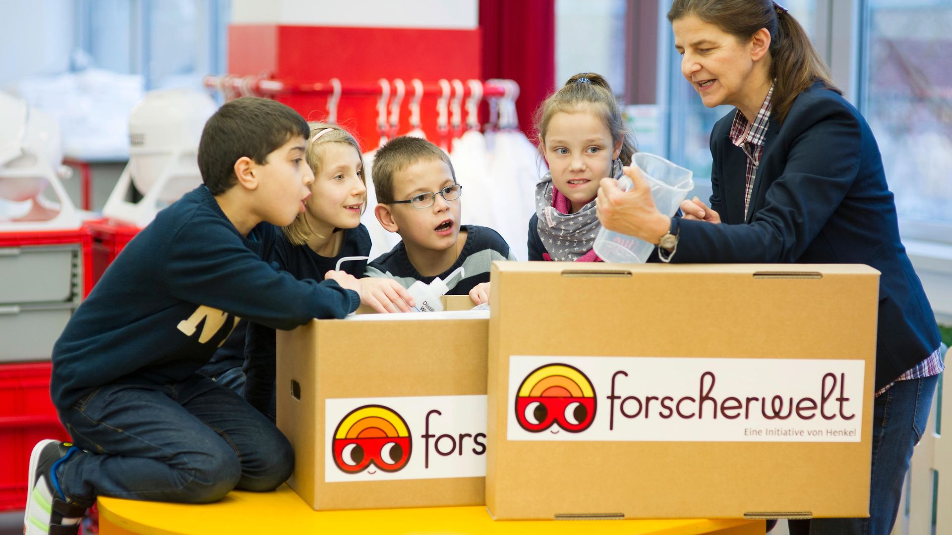 Die Kinder der Theodor Heuss Grundschule inspizieren mit ihrer Lehrerin den Inhalt der Forscherkiste.
